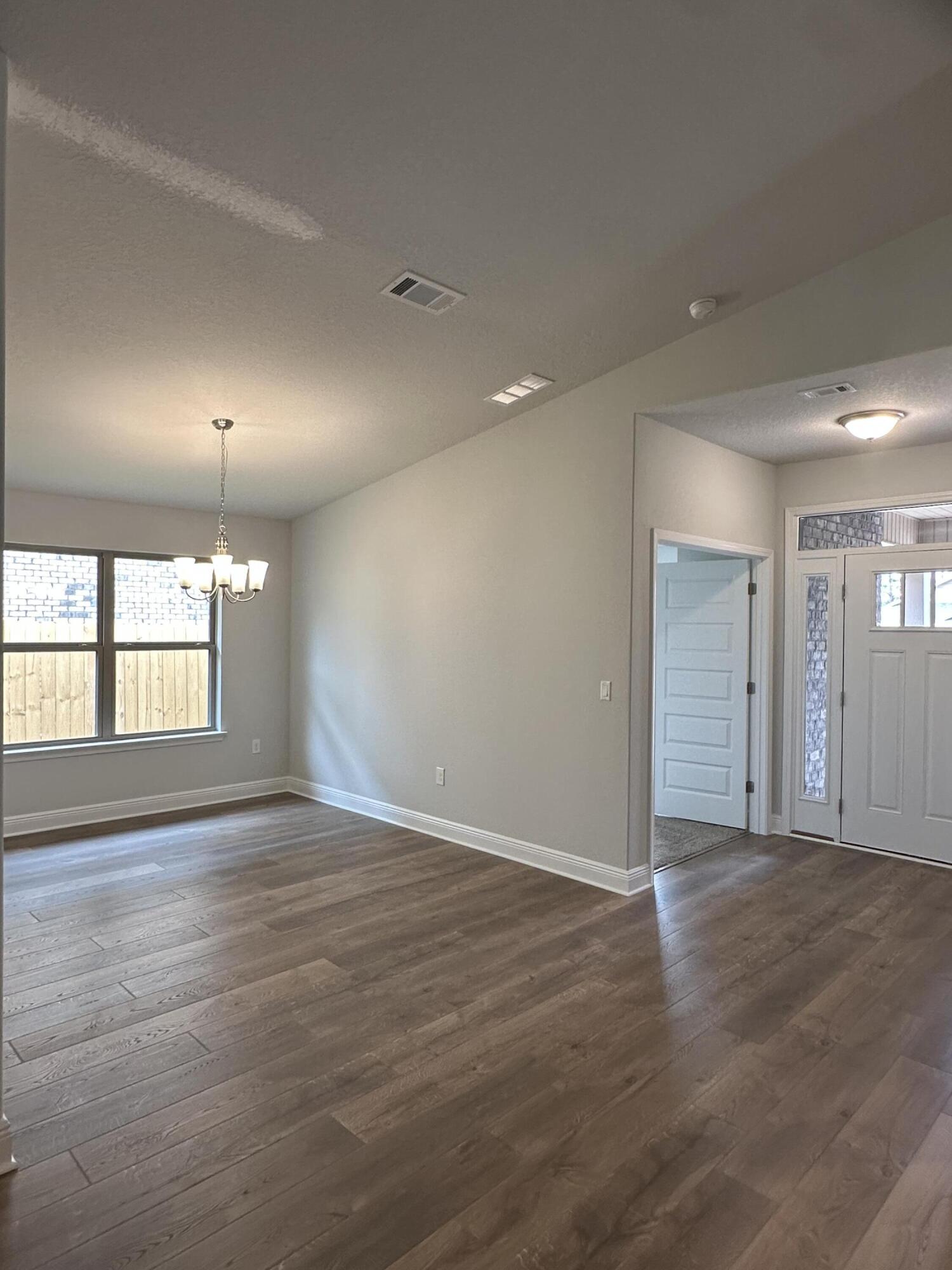 191 Ridgeway Circle Crestview, FL 32536 - Photo 8 of 26 an empty room with wooden floor and windows