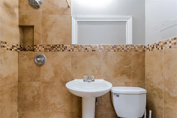 a bathroom with a sink a toilet and a mirror