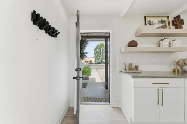 a kitchen with white cabinets and a potted plant