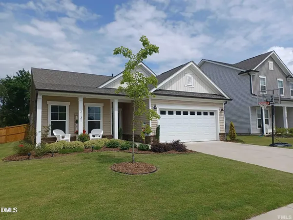 a front view of a house with a garden and yard