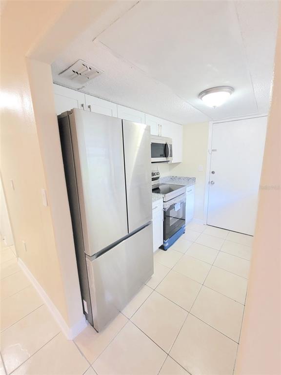 5338 Orange Avenue, Unit B Seffner, FL 33584 - Photo 5 of 8 a kitchen with a refrigerator a stove top oven and a sink