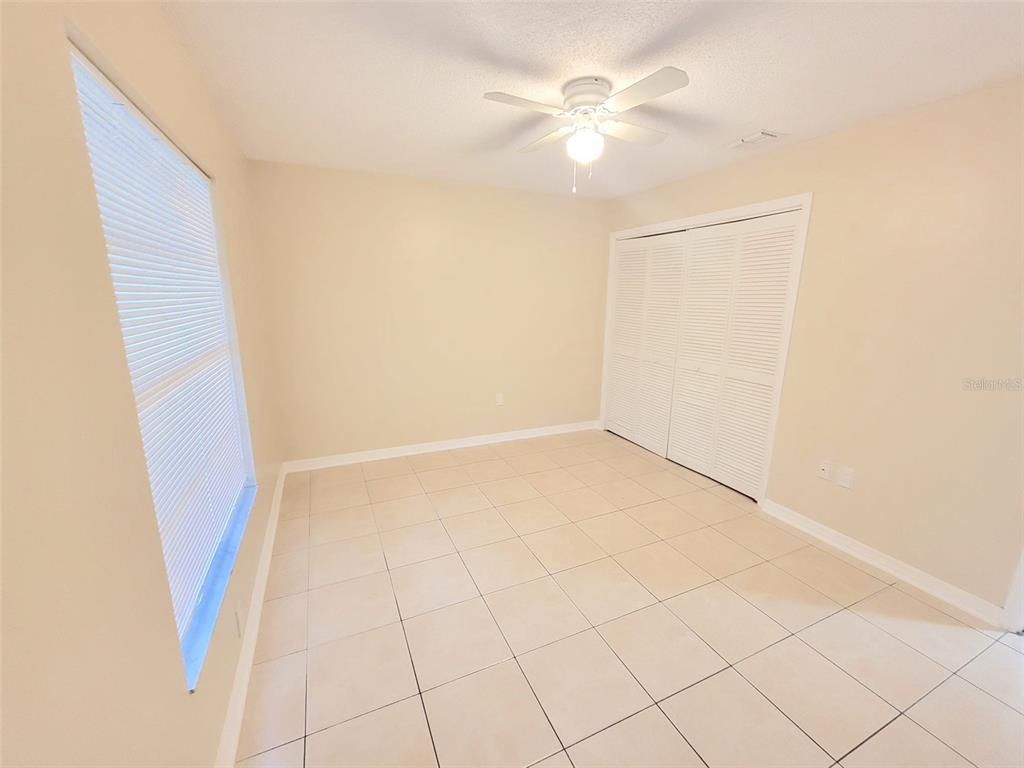 5338 Orange Avenue, Unit B Seffner, FL 33584 - Photo 6 of 8 an empty room with a ceiling fan and a window