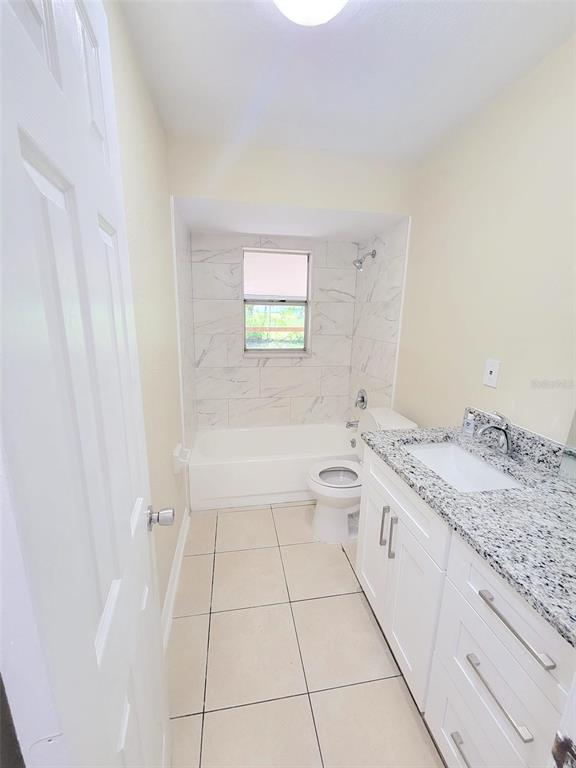 5338 Orange Avenue, Unit B Seffner, FL 33584 - Photo 7 of 8 a bathroom with a granite countertop sink a toilet and bathtub