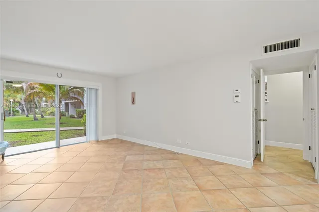an empty room with floor to ceiling windows and garden