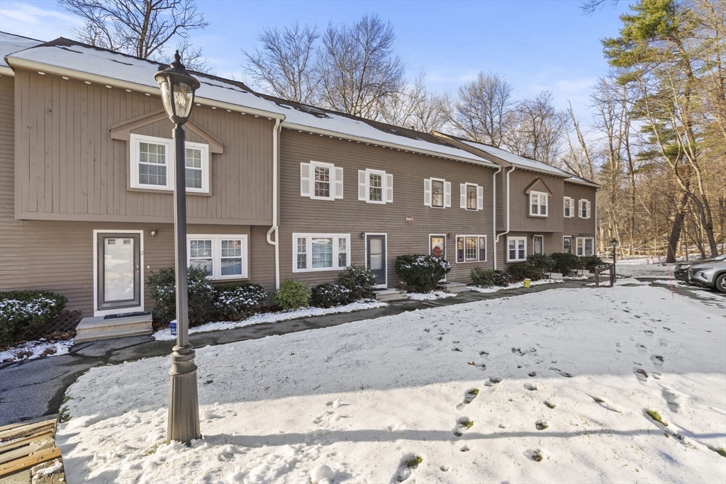 4 Apple Ridge Road, Unit 6 Maynard, MA 01754 - Photo 28 of 40 a front view of a house with a yard covered in snow