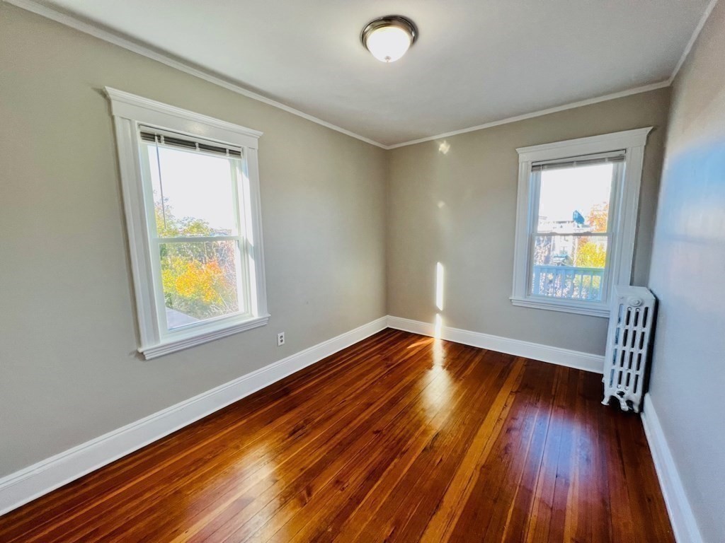 22 Gardena Street, Unit 3 Boston, MA 02135 - Photo 11 of 17 a view of an empty room with wooden floor and a window