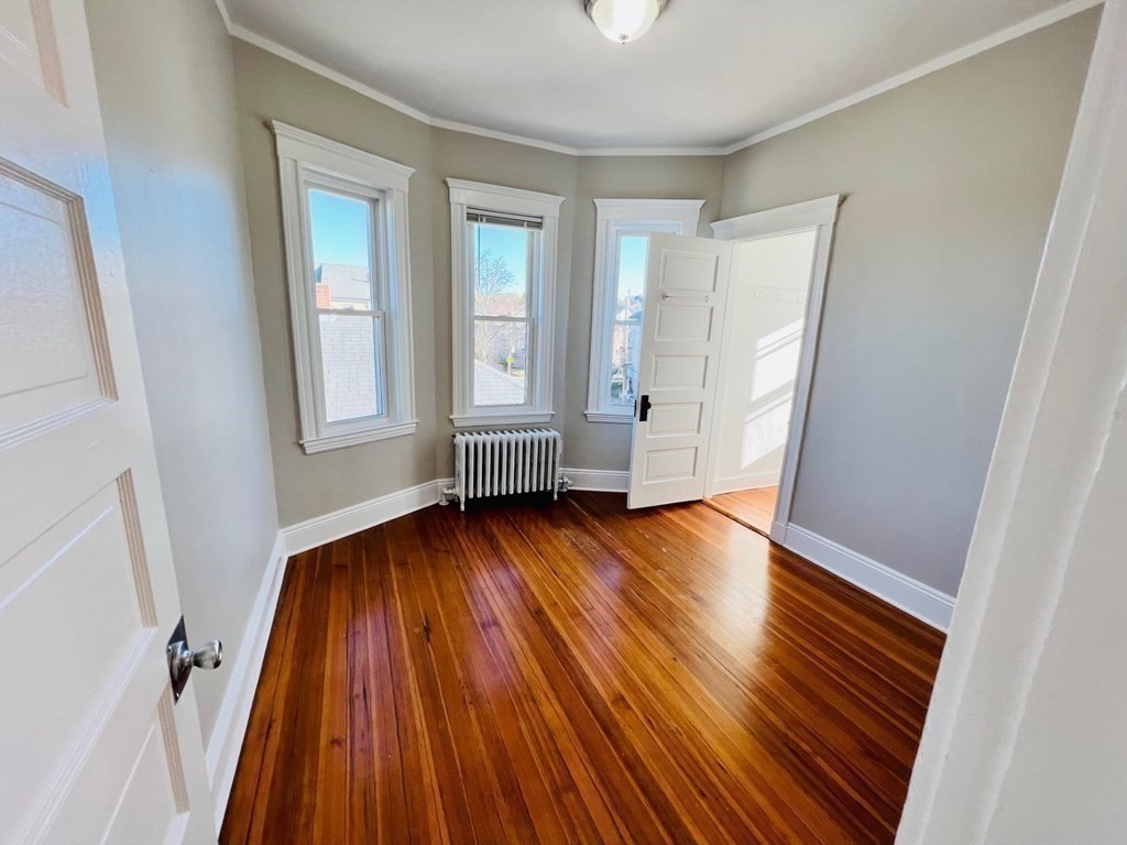 22 Gardena Street, Unit 3 Boston, MA 02135 - Photo 13 of 17 an empty room with wooden floor and windows