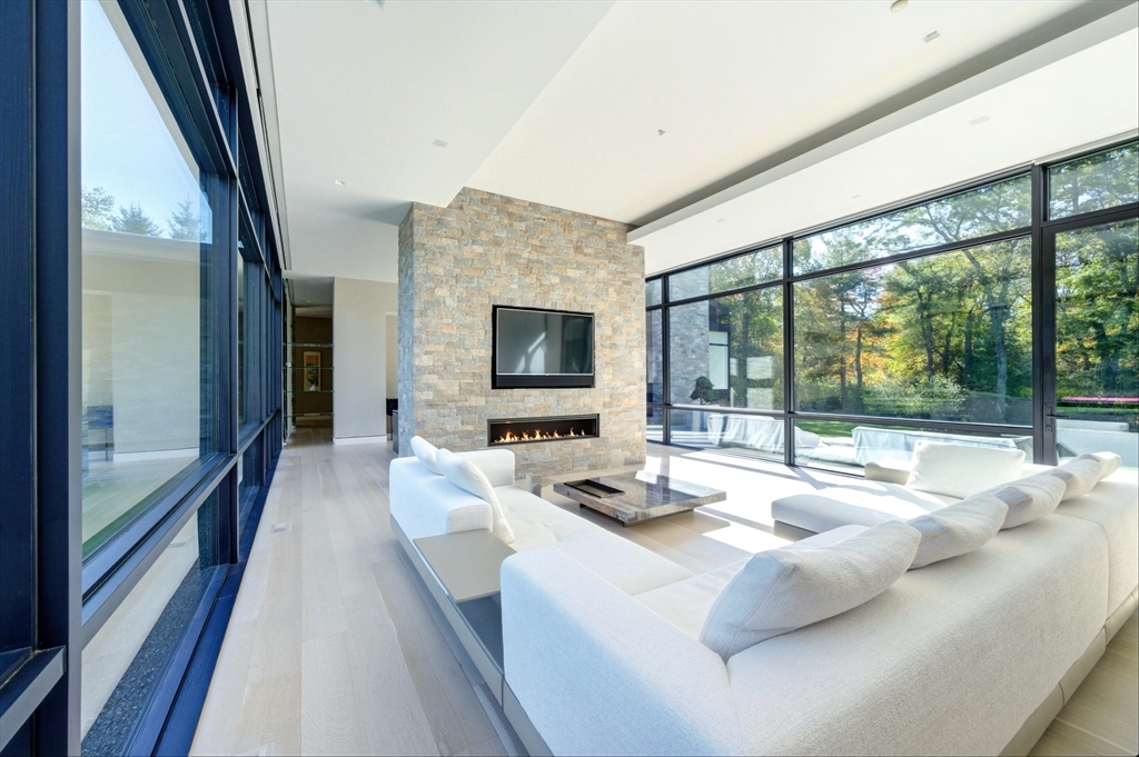 63 Sylvan Lane Weston, MA 02493 - Photo 14 of 28 a living room with couch floor to ceiling window and a flat screen tv