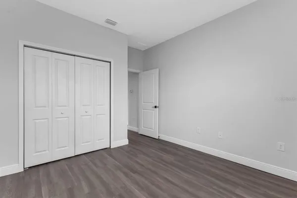 a view of an empty room with wooden floor