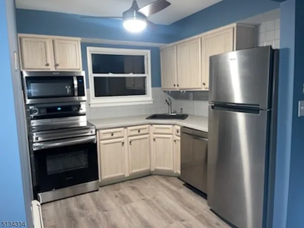 a kitchen with stainless steel appliances and refrigerator