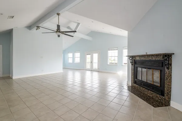 a view of an empty room with window and fireplace