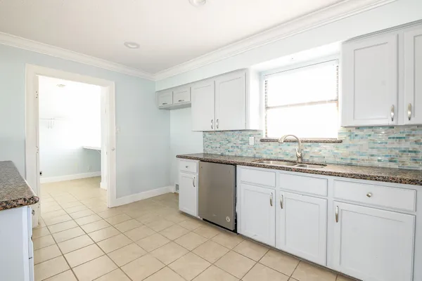 a kitchen with granite countertop white cabinets and white appliances