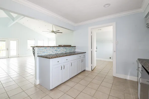 a kitchen with granite countertop white cabinets and white appliances