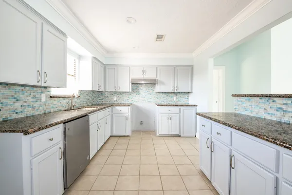 a kitchen with a sink stove and cabinets