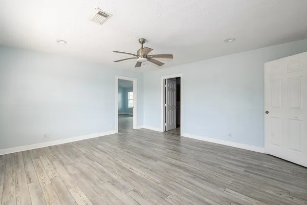a view of an empty room with wooden floor