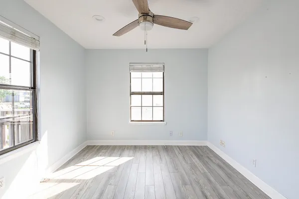 an empty room with a window and wooden floor