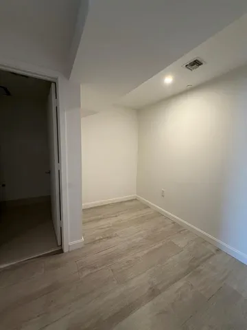 an empty room with wooden floor and door