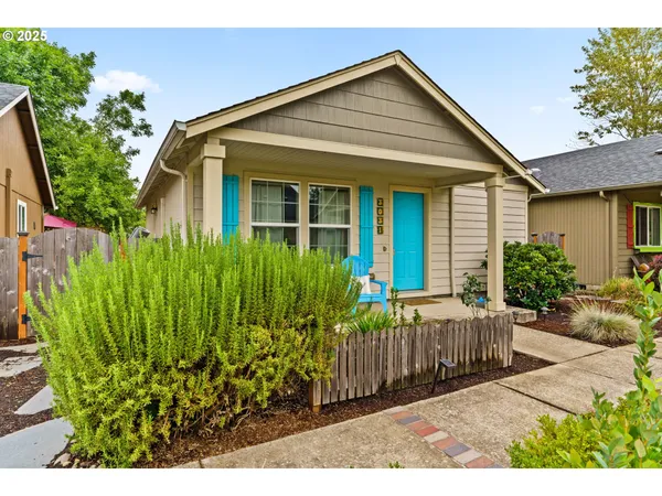 a view of a house with a small yard and flower plants