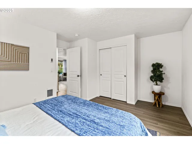 a bedroom with a bed and a painting on the wall