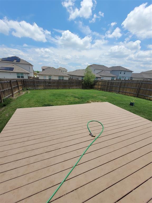 14917 Gypsum Mill Road Manor, TX 78653 - Photo 14 of 28 An inviting backyard deck extends to a lush green lawn, fully fenced for seclusion.