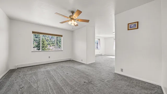 an empty room with windows and fan