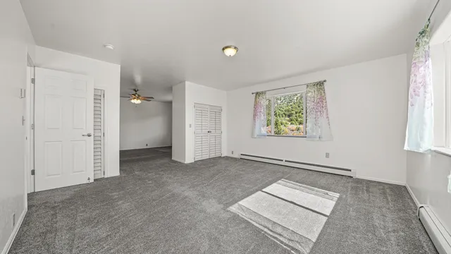 an empty room with windows and closet