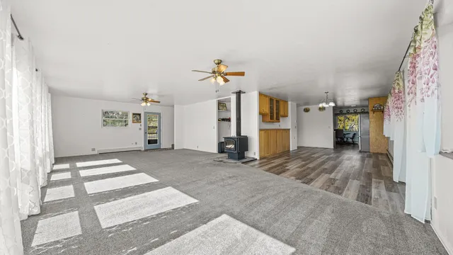 a view of a hallway with wooden floor and a refrigerator