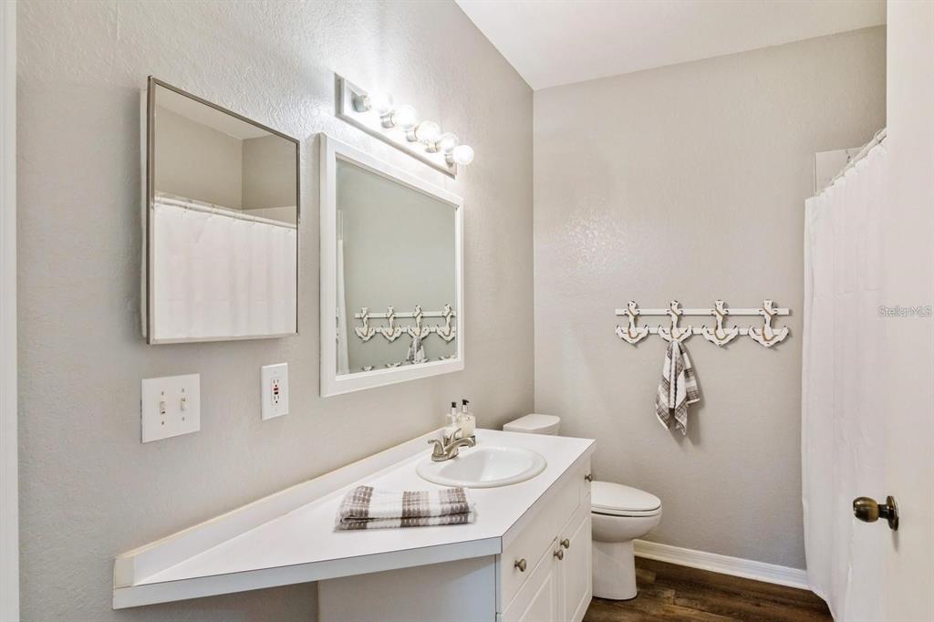 5174 Northridge Road, Unit 111 Sarasota, FL 34238 - Photo 2 of 9 a bathroom with a sink a toilet and mirror