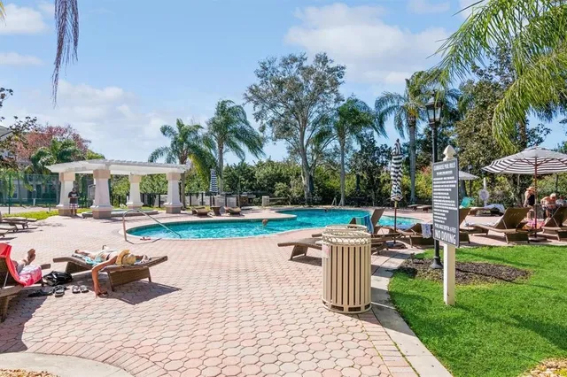 a view of a swimming pool and lounge chairs in patio