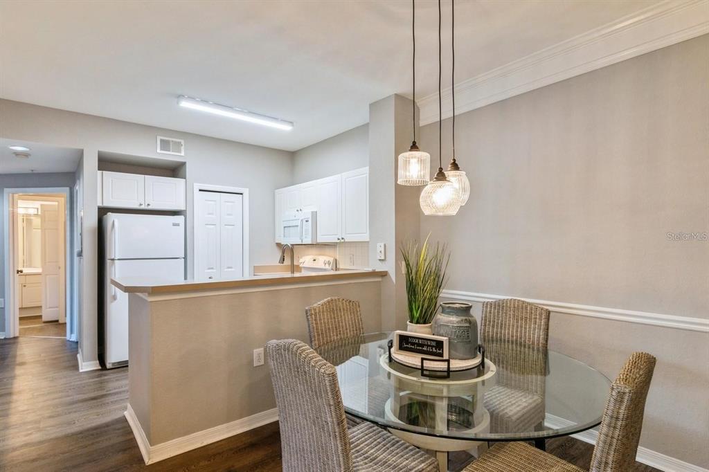 5174 Northridge Road, Unit 111 Sarasota, FL 34238 - Photo 7 of 9 a dining room with furniture and wooden floor