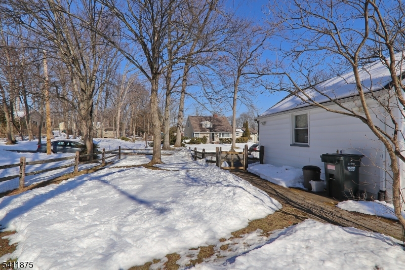 1314 Wood Valley Road Mountainside, NJ 07092 - Photo 37 of 40 a view of a backyard with table and chairs under a large tree