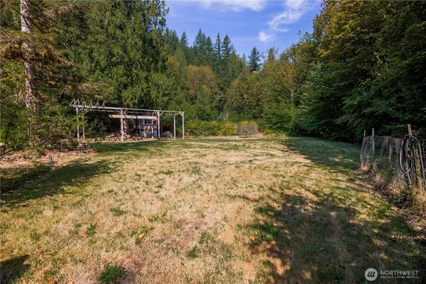 a view of a yard with wooden fence