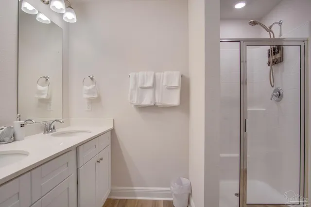 a bathroom with a shower sink vanity and mirror