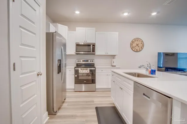 a kitchen with stainless steel appliances granite countertop a refrigerator sink and cabinets