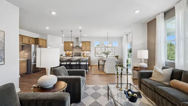 a living room with furniture kitchen view and a window