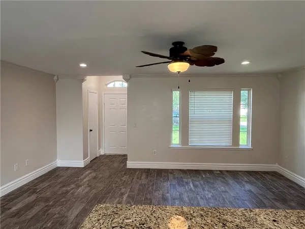 a view of an empty room and window and wooden floor