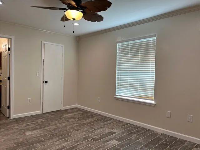 a view of an empty room with a window and a ceiling fan