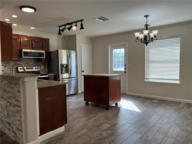 a kitchen with stainless steel appliances granite countertop a refrigerator and a sink
