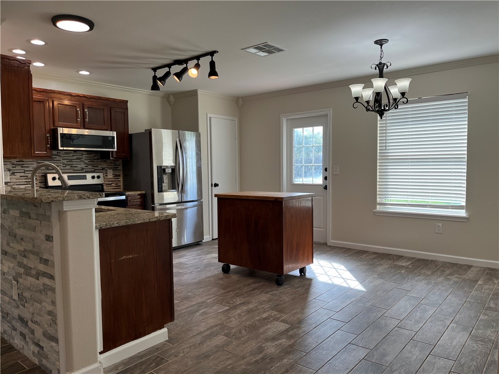 1219 Sacramento Street Portland, TX 78374 - Photo 4 of 40 a kitchen with stainless steel appliances granite countertop a refrigerator and a sink