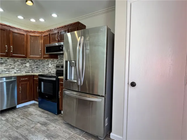 a modern kitchen with stainless steel appliances granite countertop a refrigerator and a sink