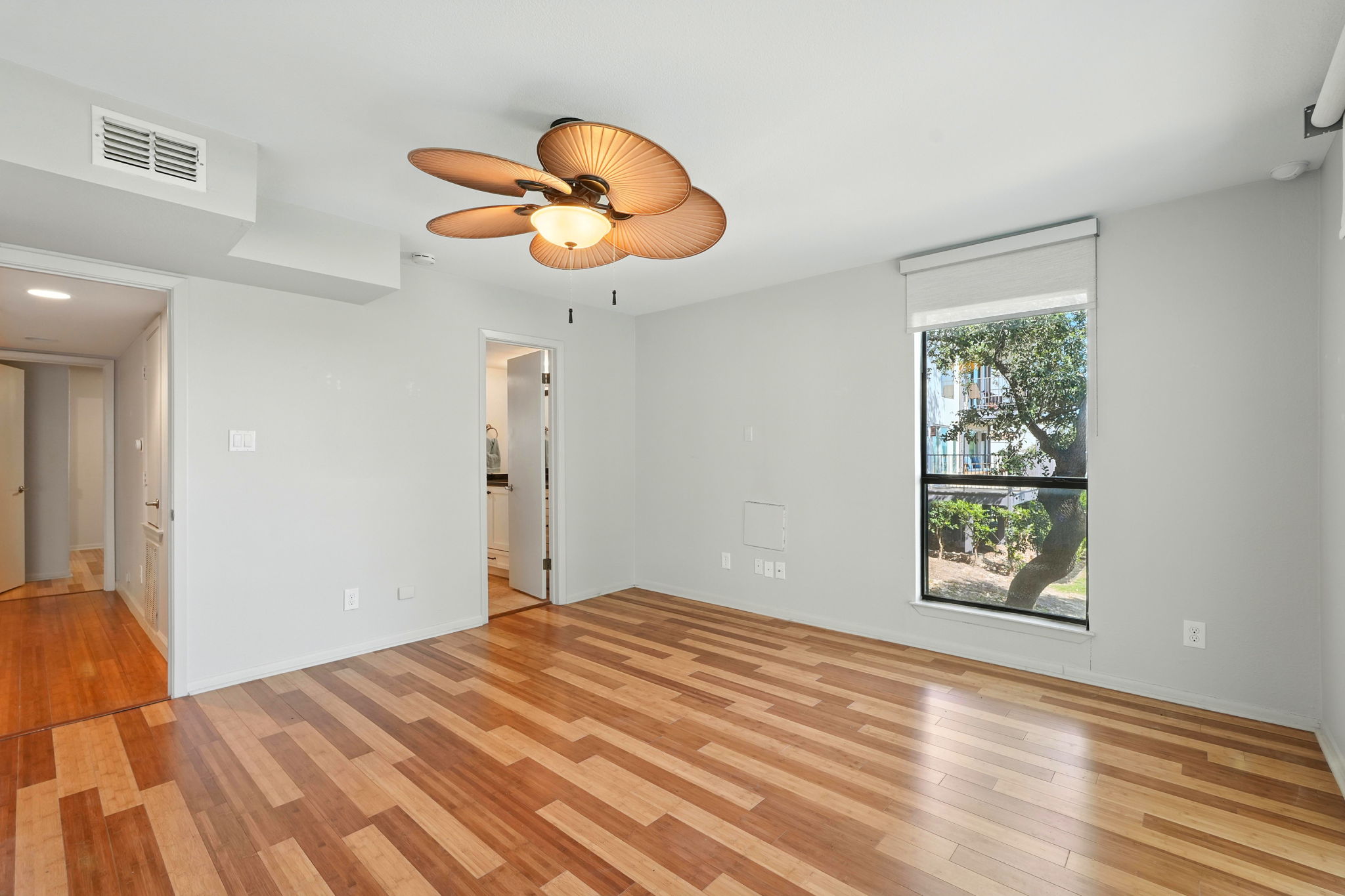 2918 Ranch Road 620 North, Unit C115 Austin, TX 78734 - Photo 16 of 39 Unfurnished bedroom featuring light wood finished floors, a ceiling fan, and ensuite bath