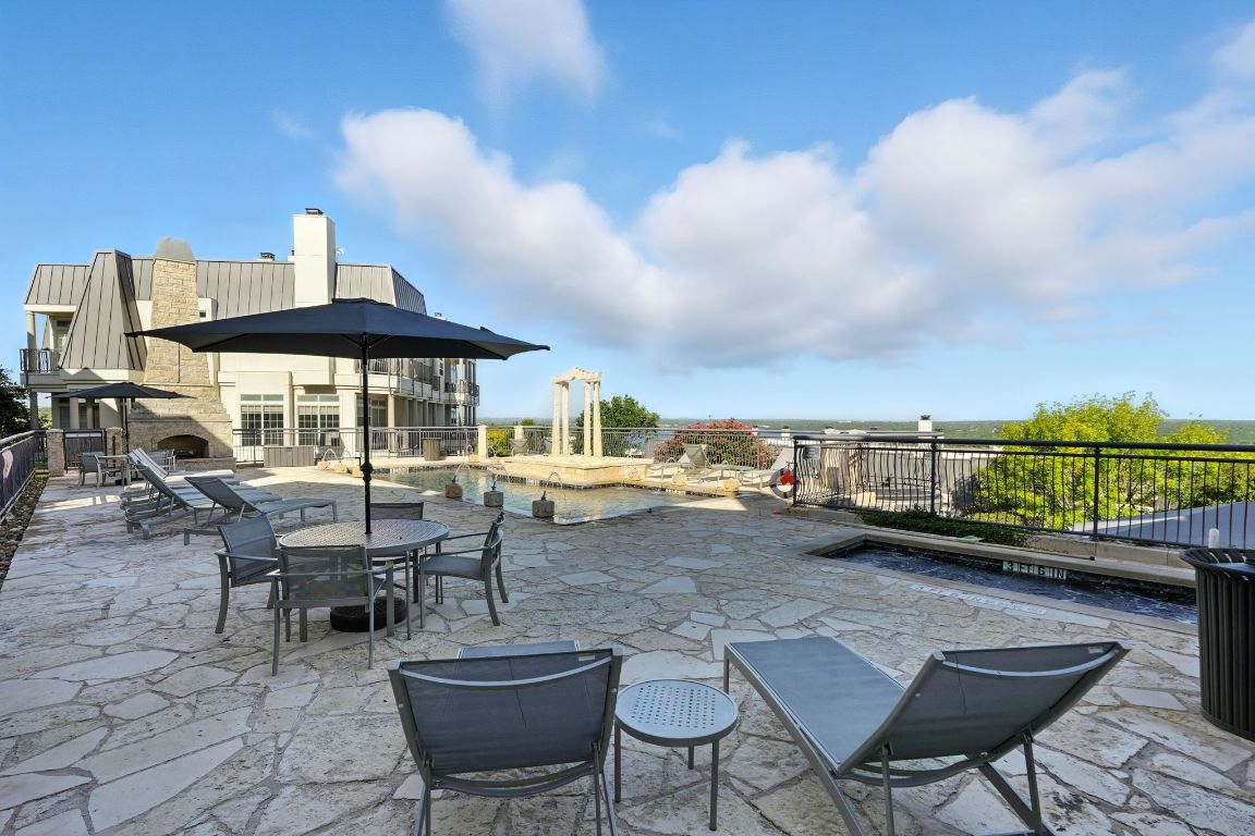2918 Ranch Road 620 North, Unit C115 Austin, TX 78734 - Photo 36 of 39 View of patio / terrace featuring an outdoor stone fireplace and a swimming pool
