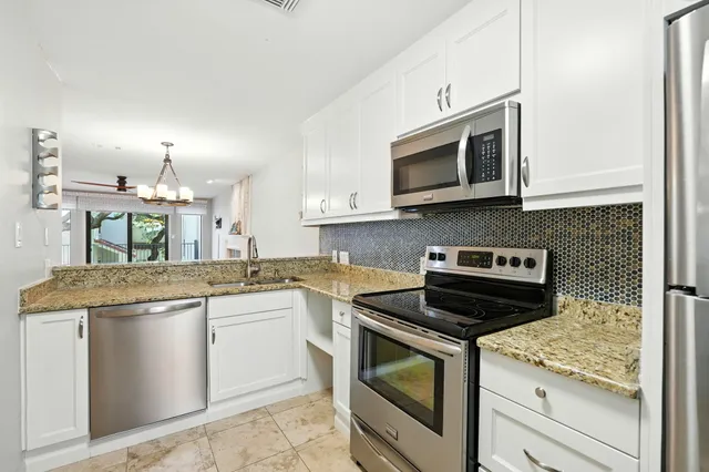 a kitchen with stainless steel appliances granite countertop a stove and a microwave