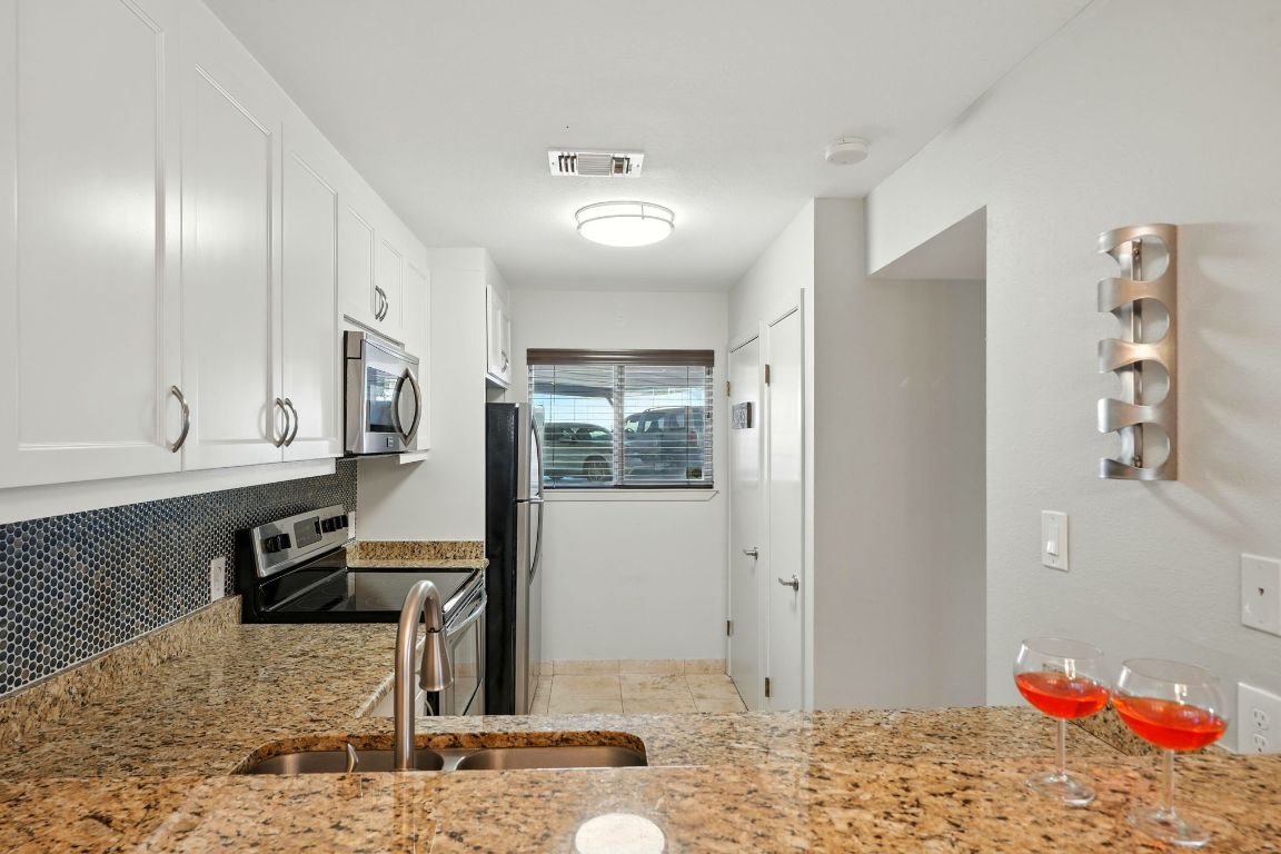 2918 Ranch Road 620 North, Unit C115 Austin, TX 78734 - Photo 10 of 39 Kitchen featuring light stone countertops, stainless steel appliances, and white cabinetry