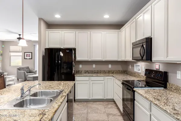a kitchen with stainless steel appliances granite countertop a sink stove and microwave