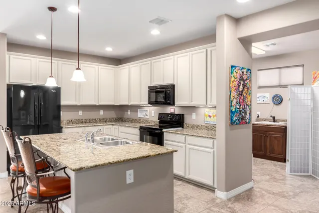 a kitchen with a refrigerator a sink and chairs