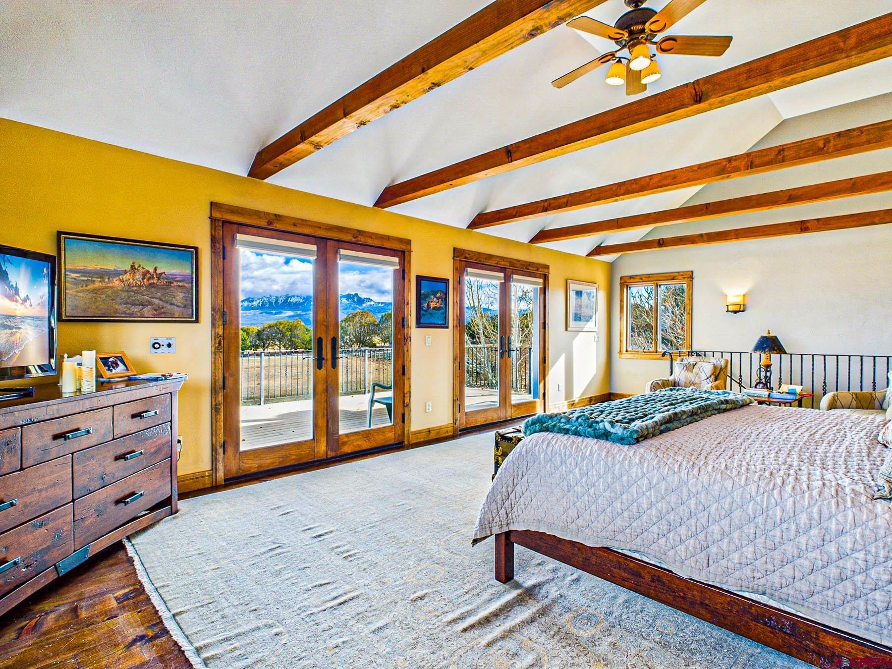 2741 7750th Road Crawford, CO 81415 - Photo 21 of 45 a bedroom with a bed and large windows