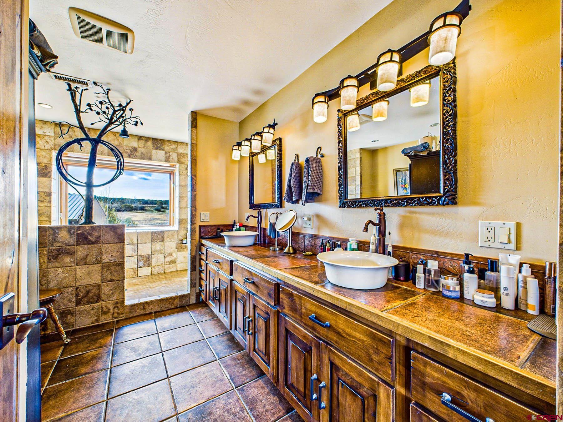 2741 7750th Road Crawford, CO 81415 - Photo 25 of 45 a large bathroom with a double vanity sink a mirror and a shower