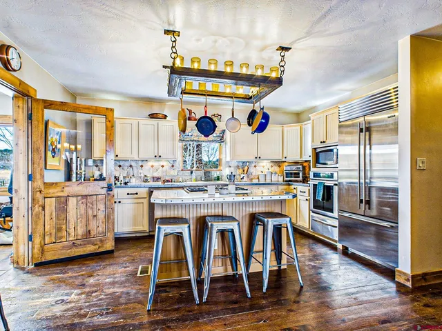 a kitchen with stainless steel appliances kitchen island granite countertop a stove and white cabinets