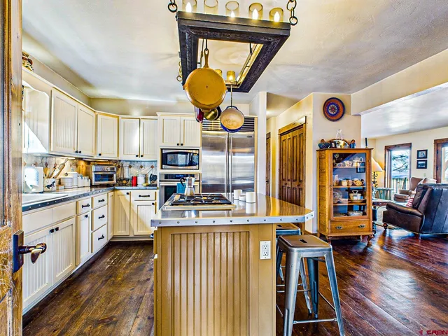 a kitchen with stainless steel appliances granite countertop a stove a sink and a refrigerator